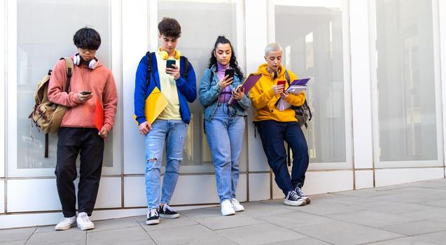 Panoramic image go college student standing outside university building using mobile phone. Copy space. Gen z lifestyle, social media addiction concept.