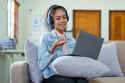 Portrait of an African American with headphones and a computer conferencing for a meeting over the Internet while working at home.