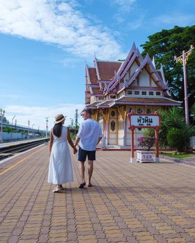 A couple of men and women are walking at Hua Hin train station in Thailand. Asian women and Caucasian men walking at the train station of Huahin
