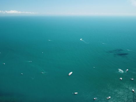Aerial boat race. Luxury cruise trip. View from above of white boat on deep blue water. Aerial view of rich yacht sailing sea. Motor boat racing wave. Summer journey on luxury ship