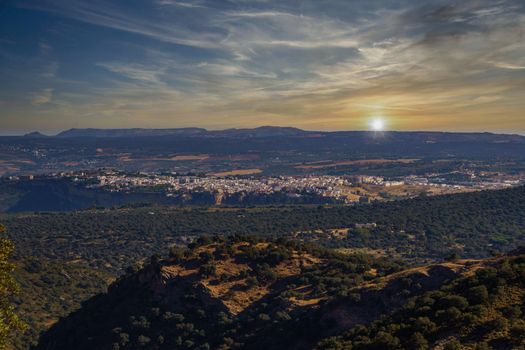 Ronda Spain cityscape at sunset with the sun about to set.