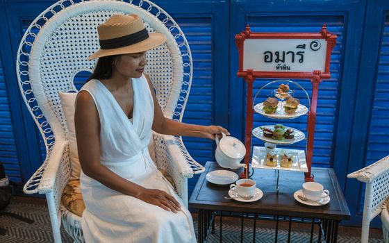 Asian women having a Luxury high tea with snacks and tea in a luxury hotel