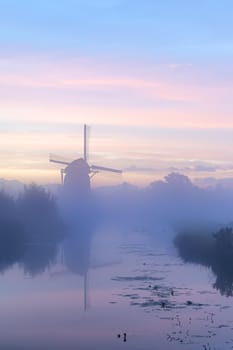 Calm and foggy golden sunrise morning on the Hazerswouder-Dorp windmill, Rietveldse, Netherlands.