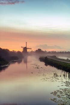 Calm and foggy golden sunrise morning on the Hazerswouder-Dorp windmill, Rietveldse, Netherlands.