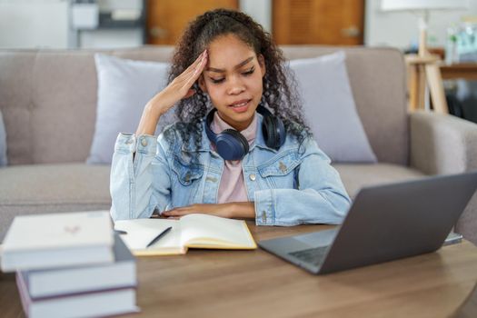 Portrait of an African American using computers and notebooks online and showing stressed faces and gestures in lessons learned