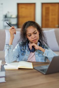 Portrait of African Americans using computers and notebooks to study online and showing doubtful faces at lessons they have learned.