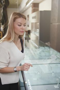 Vertical shot of a beautiful woman shopping at jewelry store