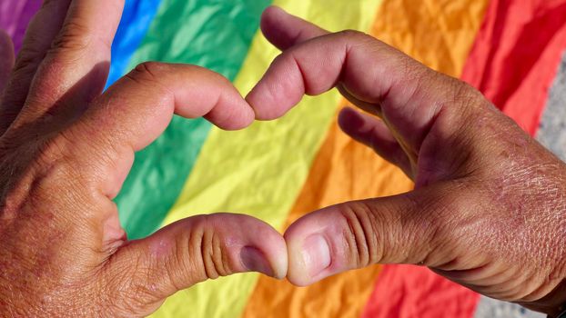 Bisexual, gay, man, person, homosexual holds heart on LGBT flag background and celebrating a gay parade, Bisexuality Day or National Coming Out Day in pride month