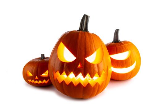 Three Halloween glowing funny lantern pumpkins isolated on white background