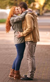 My favorite place is in your arms. a happy young couple sharing a kiss outdoors