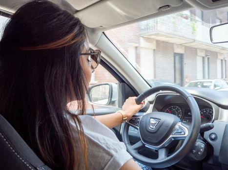 Beautiful business lady driving her car a cloudy day in summertime