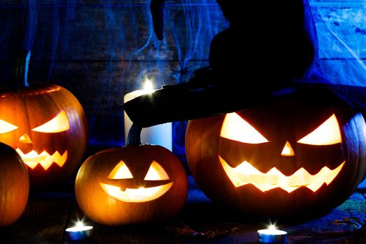 Festive mystical halloween interior. Pumpkin, spider web, burning candles, spiders on dark wooden background