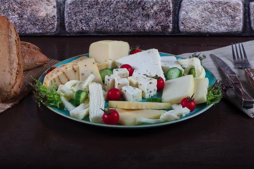 Cheese plate on a dark table. Many kinds of cheese on a plate. High quality photo