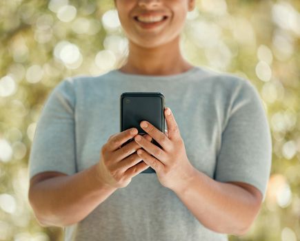 Phone, communication and woman in nature park while using a mobile app, communication tool or social media messaging outside. Closeup hands of a female with 5g network internet connection outside.