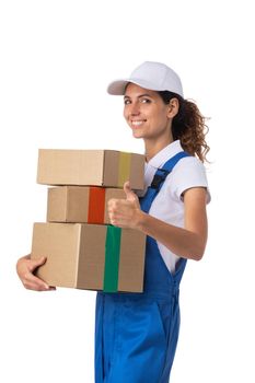 Portrait of happy smiling delivery woman with stack of boxes showing thumb up isolated on white background