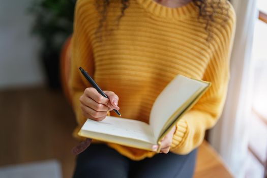 woman holding a pen to write down memories.