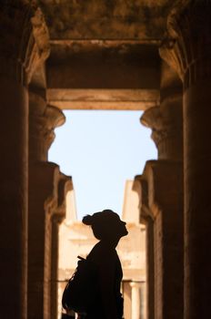 Silhouette of a woman gazing at the walls of an Edfu egyptian temple