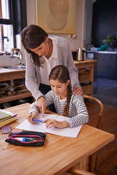 Sometimes a little help is needed. a young girl studying with her mother nearby to help