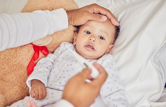 Baby, sick with covid and fever with a thermometer from a parent of an unwell kid in bed of the bedroom of their home. Hand, forehead and healthcare with a child feeling unwell and resting in a house.