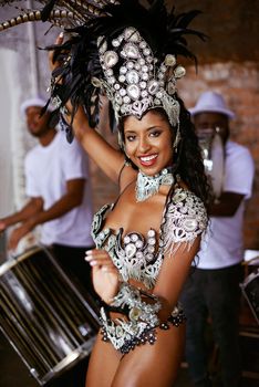Samba the night away. a beautiful samba dancer posing in a carnival with her band