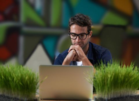 Designers are creative creatures that can often be found working in between lush herb gardens. a male entrepreneur working at his desk