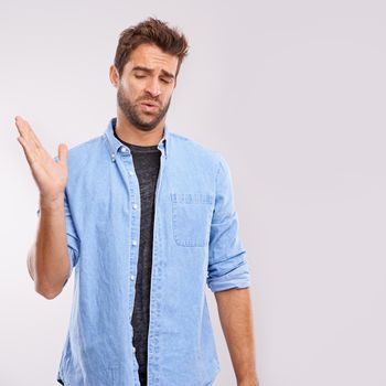 Theres no hiding his feelings. Studio shot of a handsome young man waving his hands in gesture after smelling something unpleasant