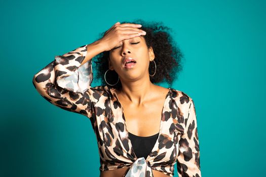 Beautiful woman is tired of work, she disappointed, helpless. Frustrated african american girl over blue background. Concept of problems and headache. High quality photo