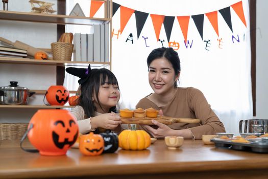 Happy family mother and child happy girl with holiday Halloween. Happy Halloween. Recipe pumpkin puree. Ingredients for pumpkin pie for Thanksgiving day.