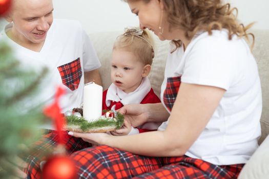 Baby child with hearing aid and cochlear implant having fun with parents in christmas room. Deaf and health