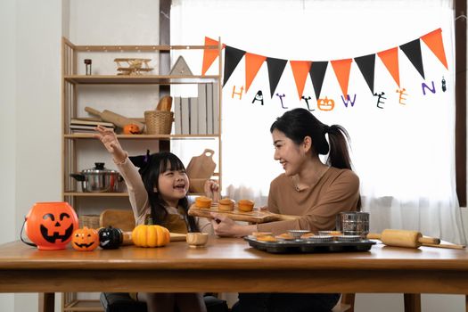 Happy family mother and child happy girl with holiday Halloween. Happy Halloween. Recipe pumpkin puree. Ingredients for pumpkin pie for Thanksgiving day.