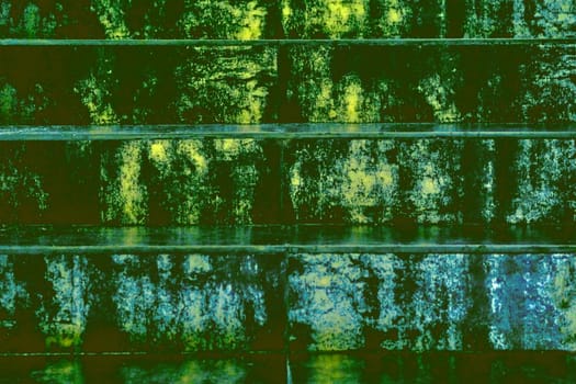 a continuous vertical brick or stone structure that encloses or divides an area of land. Green yellow emerald spotted steps as abstract background