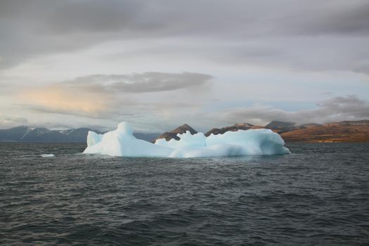 Stranded iceberg and ice near evening in arctic landscape, near Pond Inlet, Nunavut, Canada