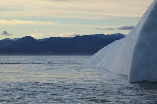 Side view of a stranded iceberg and ice near evening in arctic landscape, near Pond Inlet, Nunavut, Canada