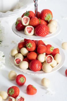 vase with white chocolate covered strawberries and fresh strawberries against porcelain vase with hydrangea, vintage still life and summer food. High quality photo