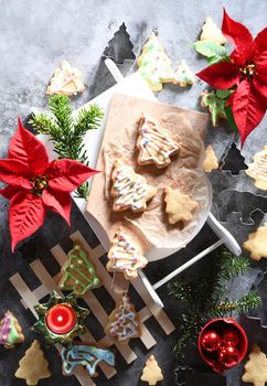 Shortbread Christmas cookies on a mini sled, around festive decor and red poinsettia flowers, family holiday, eternal traditions, flatley, homemade Christmas baking with your own hands,