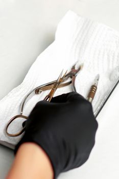 Professional manicure master prepares nail care tools on a white background with copy space