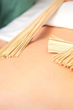 Young woman have double samurai massage with bamboo brooms in spa. Relaxation massage concept