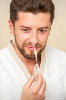 Young caucasian man receiving nasal inhalation Maholda with essential oil in the nose at a hospital