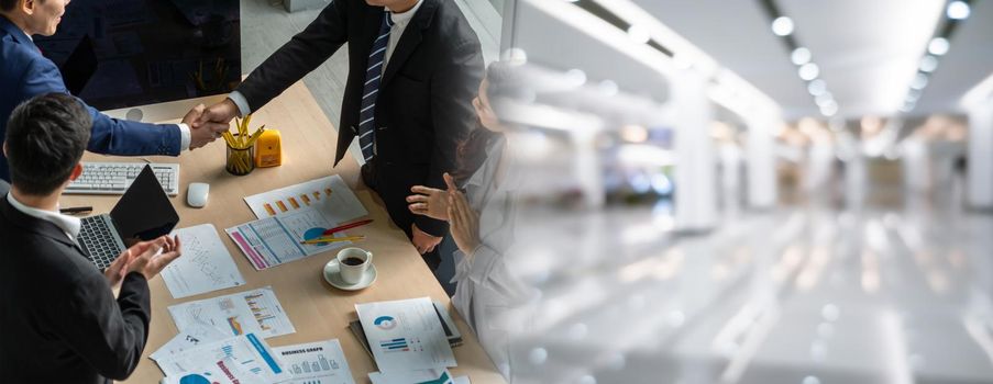 Group business people handshake at meeting table in widen view in office together with confident shot from top view . Young businessman and businesswoman workers express agreement of investment deal.