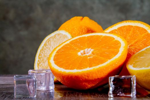 Lemons and oranges with ice. Preparation of a cocktail of citrus fruits. Fruit drink with ice. Copyspace.