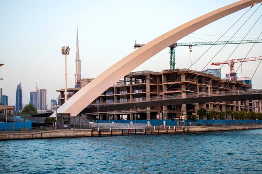 Part of "Tolerance bridge" structure in Dubai. "Dubai water canal", UAE. Tallest building in the world "Burj Khalifa" can also be seen on foreground. Outdoors