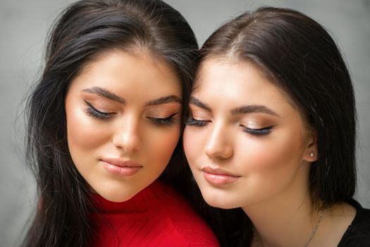 Portrait of young beautiful two women with long lashes and closed eyes after eyelash extensions