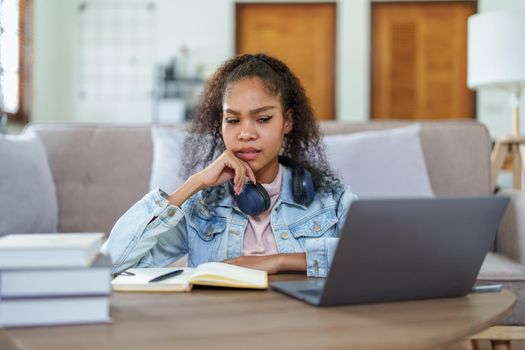 Portrait of an African American using computers and notebooks online and showing stressed faces and gestures in lessons learned