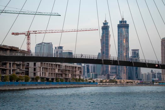 Part of "Tolerance bridge" structure in Dubai. "Dubai water canal", UAE. "Business Bay" district of a city can also be seen on foreground. Outdoors