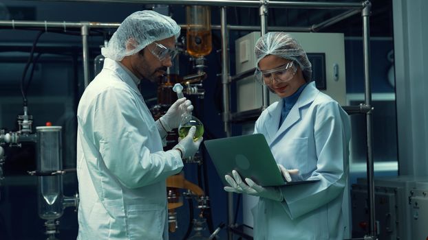 Two scientist in professional uniform working in laboratory for chemical and biomedical experiment