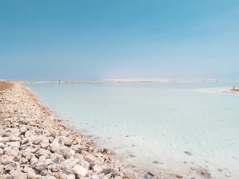 Landscape view on Dead Sea salt crystals formations, clear cyan green calm water at Ein Bokek beach, Israel