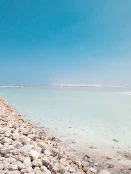 Landscape view on Dead Sea salt crystals formations, clear cyan green calm water at Ein Bokek beach, Israel