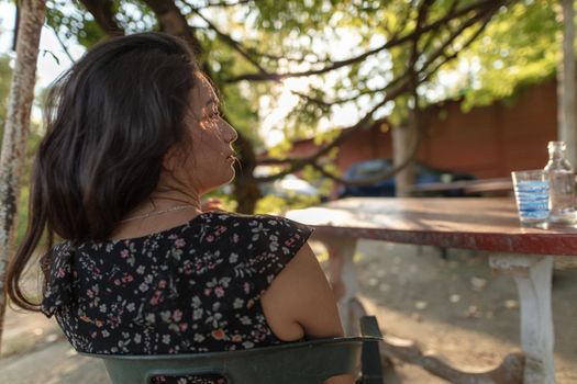 young adult latino woman drinking beer outdoors