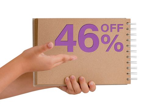 46 percent discount on isolate. Notepad from recycled paper in the hands of a child with text, sale up to 46 percent. The child is holding a notepad demonstrating a big sale