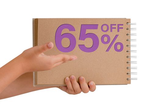 65 percent discount on isolate. Notepad from recycled paper in the hands of a child with text, sale up to 65 percent. The child is holding a notepad demonstrating a big sale
